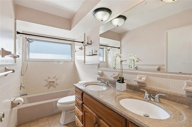 a bathroom with a granite countertop sink toilet a mirror and bathtub