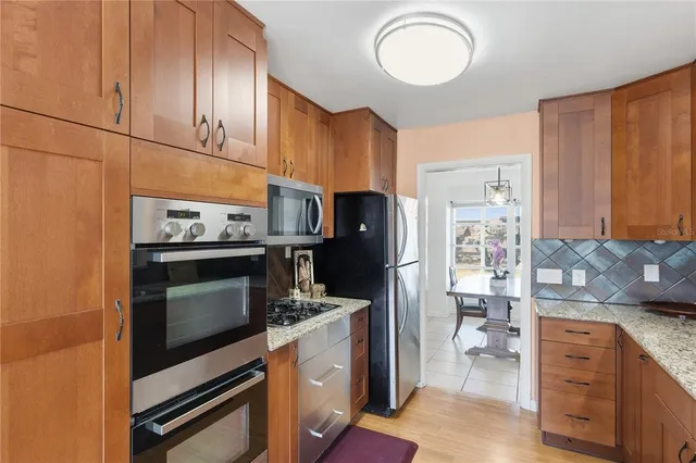 a kitchen with stainless steel appliances a stove a refrigerator and cabinets