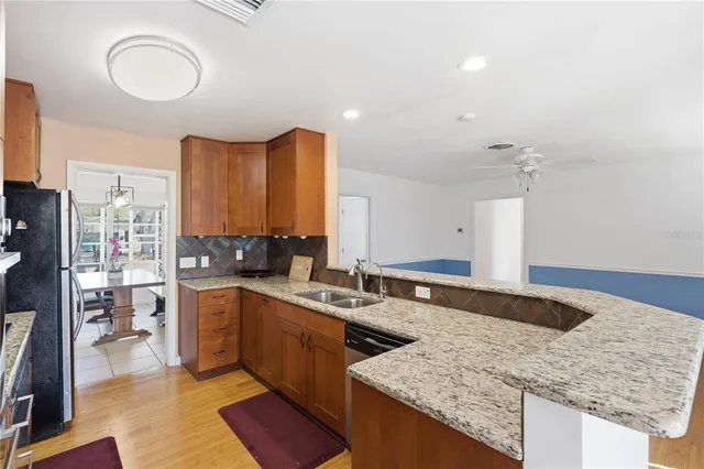 a kitchen with stainless steel appliances granite countertop a sink stove and cabinets