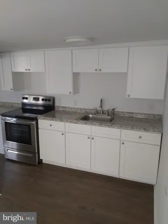 a kitchen with granite countertop white cabinets and stainless steel appliances