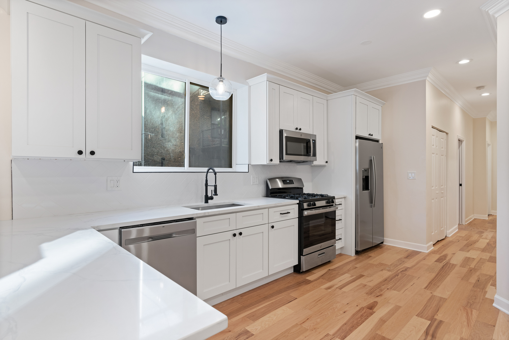 2315 West Rice Street, Unit 1N Chicago, IL 60622 - Photo 3 of 37 a kitchen with a sink stainless steel appliances and white cabinets