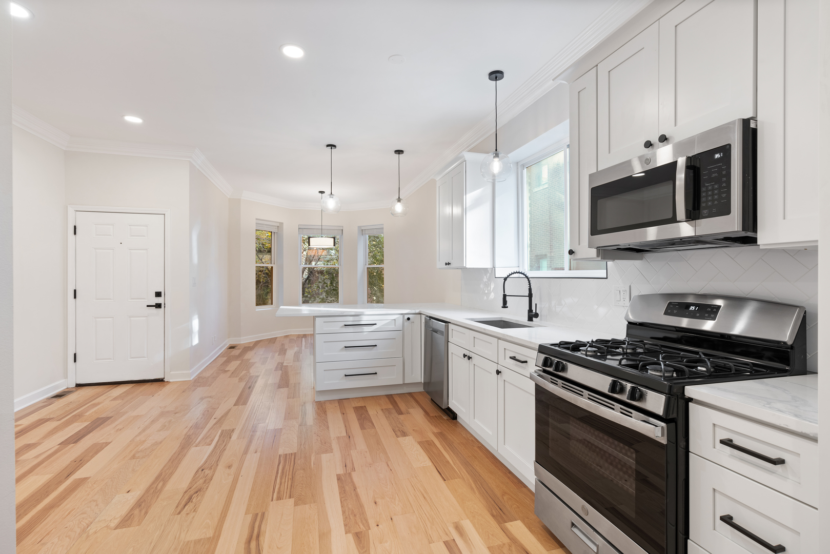 2315 West Rice Street, Unit 1N Chicago, IL 60622 - Photo 6 of 37 a large kitchen with stainless steel appliances granite countertop a stove and a wooden floors