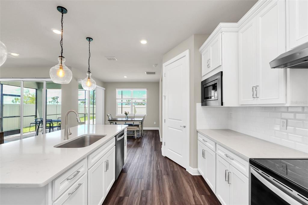 2001 Spring Shower Circle Kissimmee, FL 34744 - Photo 7 of 25 a kitchen with stainless steel appliances a stove a sink a refrigerator a center island with wooden floor and cabinets