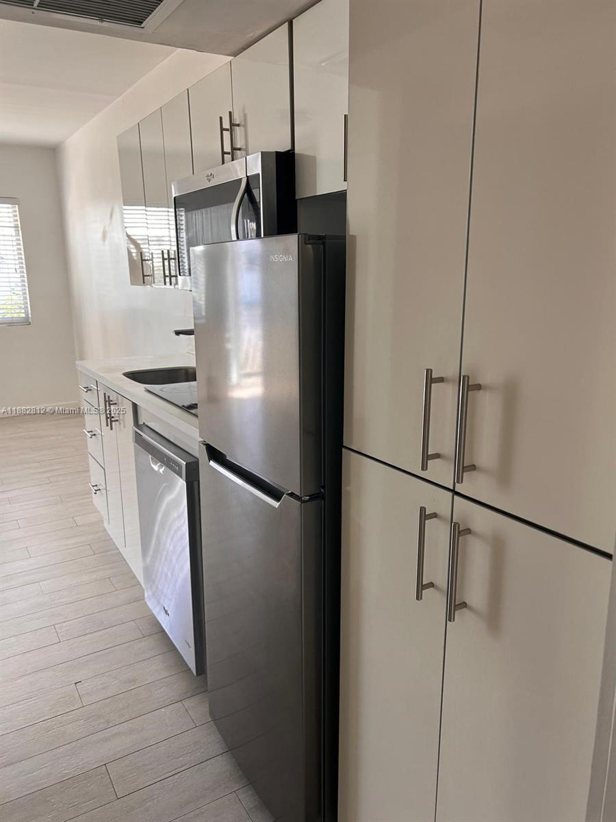 1601 Meridian Avenue, Unit 202 Miami Beach, FL 33139 - Photo 5 of 16 a kitchen with stainless steel appliances a refrigerator and a stove top oven