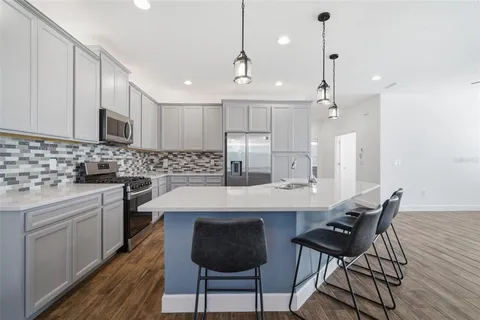 a kitchen with kitchen island a stove a sink and a refrigerator