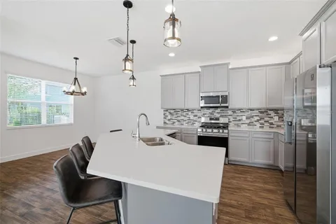 a kitchen with a refrigerator a sink dishwasher with a dining table and chairs
