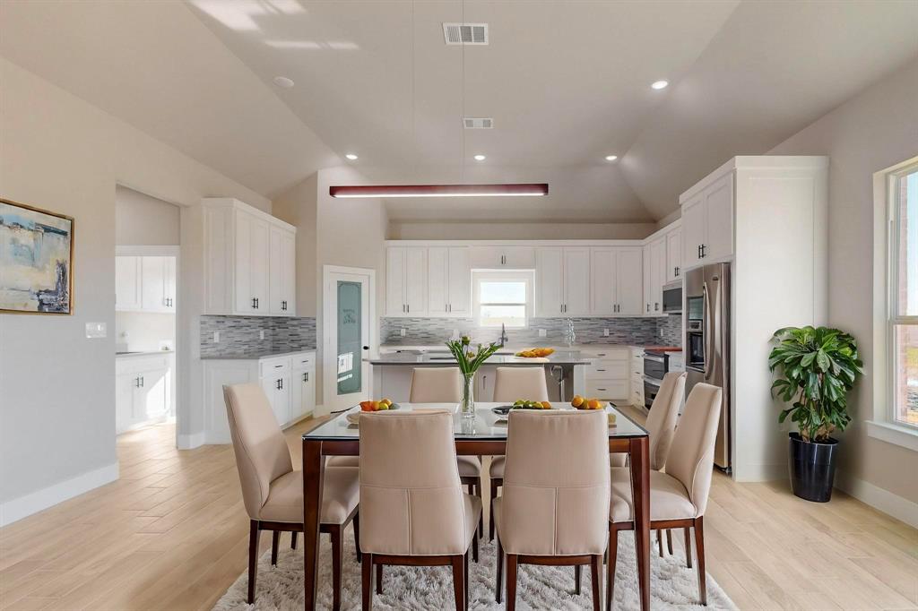 a dining room with stainless steel appliances granite countertop a dining table chairs and granite counter tops