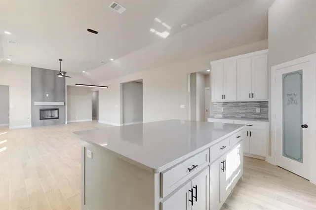 a kitchen with white cabinets appliances and center island
