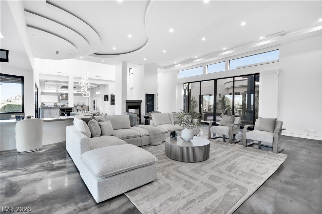 10 Ridge Blossom Road Las Vegas, NV 89135 - Photo 63 of 64 A spacious, luminous great room features an open floor plan and large sliding glass doors, seamlessly connecting indoor and outdoor living.