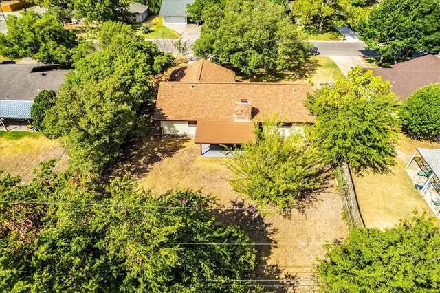 a sign that is sitting in front of a tree