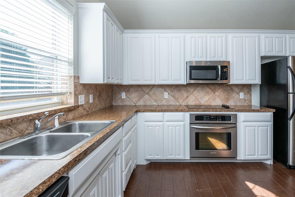 10913 Golfview Way Benbrook, TX 76126 - Photo 12 of 19 a kitchen with granite countertop a stove top oven a sink and dishwasher