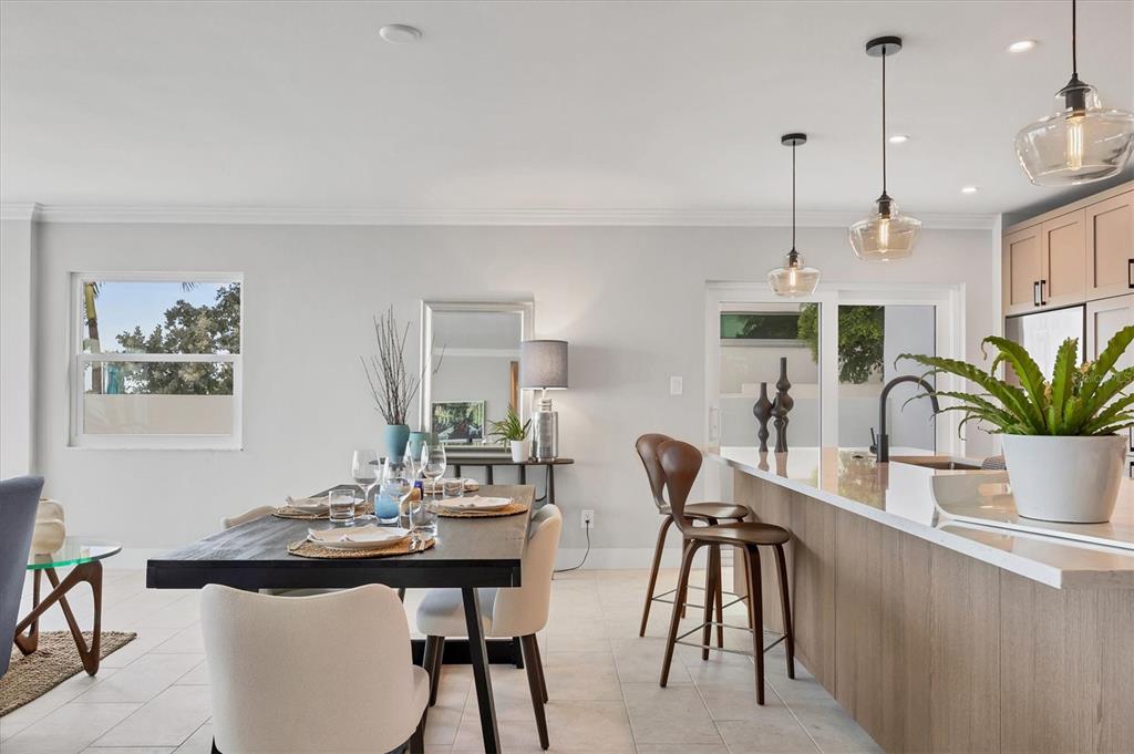 226 Golden Gate Point, Unit 12 Sarasota, FL 34236 - Photo 29 of 52 a dining room with furniture potted plants and wooden floor