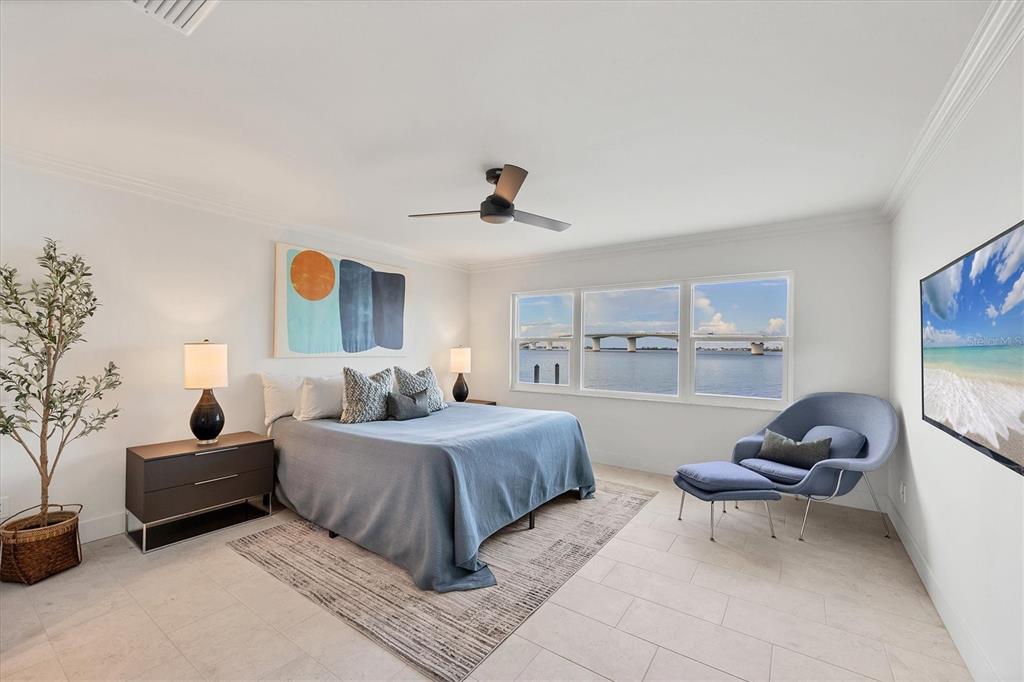 226 Golden Gate Point, Unit 12 Sarasota, FL 34236 - Photo 32 of 52 a bedroom with a bed a couch and a painting on the wall