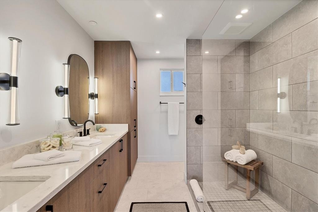 226 Golden Gate Point, Unit 12 Sarasota, FL 34236 - Photo 36 of 52 a bathroom with a double vanity sink mirror and shower