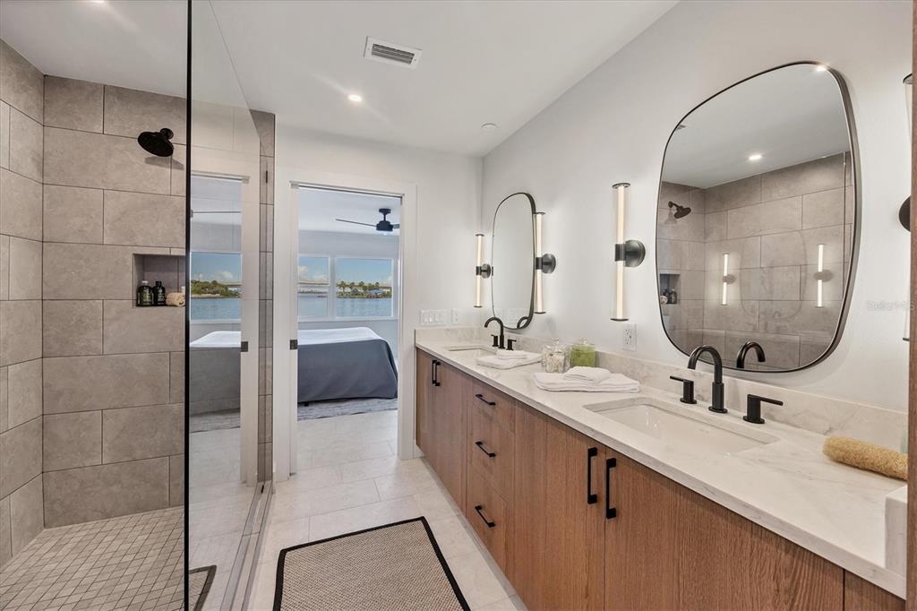 226 Golden Gate Point, Unit 12 Sarasota, FL 34236 - Photo 37 of 52 a bathroom with a double vanity sink a toilet and a mirror
