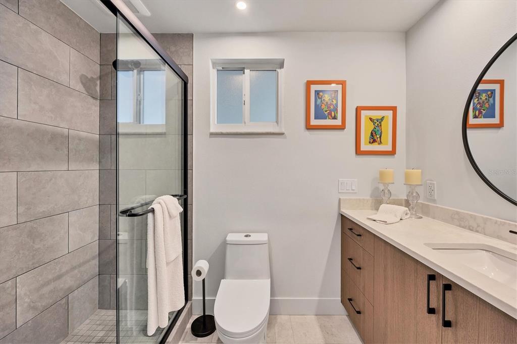 226 Golden Gate Point, Unit 12 Sarasota, FL 34236 - Photo 39 of 52 a bathroom with a granite countertop sink a toilet and a mirror