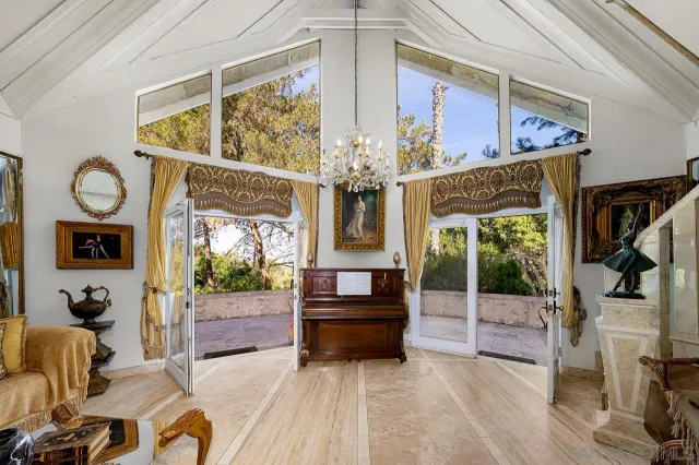 a living room with furniture a fireplace and a chandelier