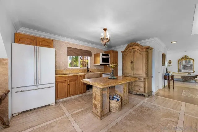 a kitchen with stainless steel appliances granite countertop a refrigerator a sink a stove and a dining table view