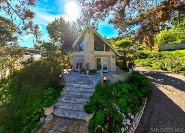 a front view of a house with a yard and green space