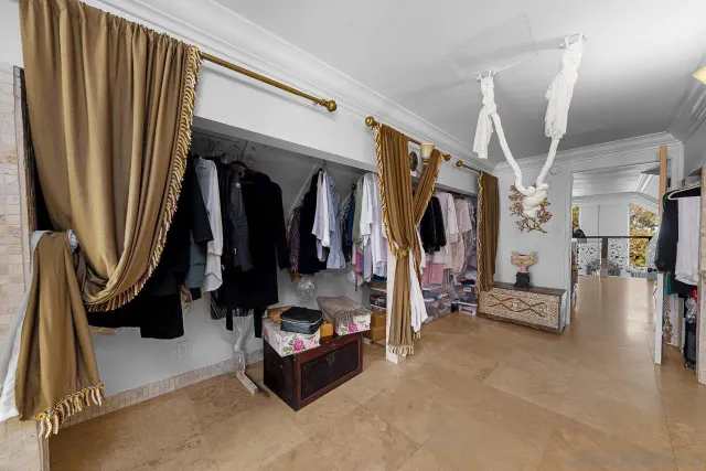 a room with lots of white furniture and a rug