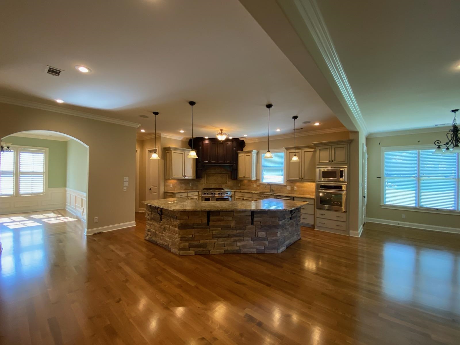 930 Snowden Farm Road Collierville, TN 38017 - Photo 13 of 38 a large living room with kitchen view and a wooden floor
