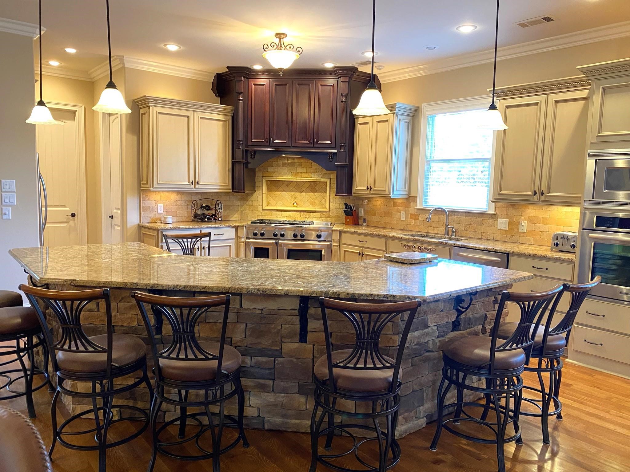 930 Snowden Farm Road Collierville, TN 38017 - Photo 14 of 38 a kitchen with a dining table chairs and wooden cabinets