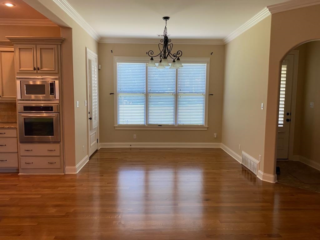 930 Snowden Farm Road Collierville, TN 38017 - Photo 16 of 38 an empty room with wooden floor cabinet and windows