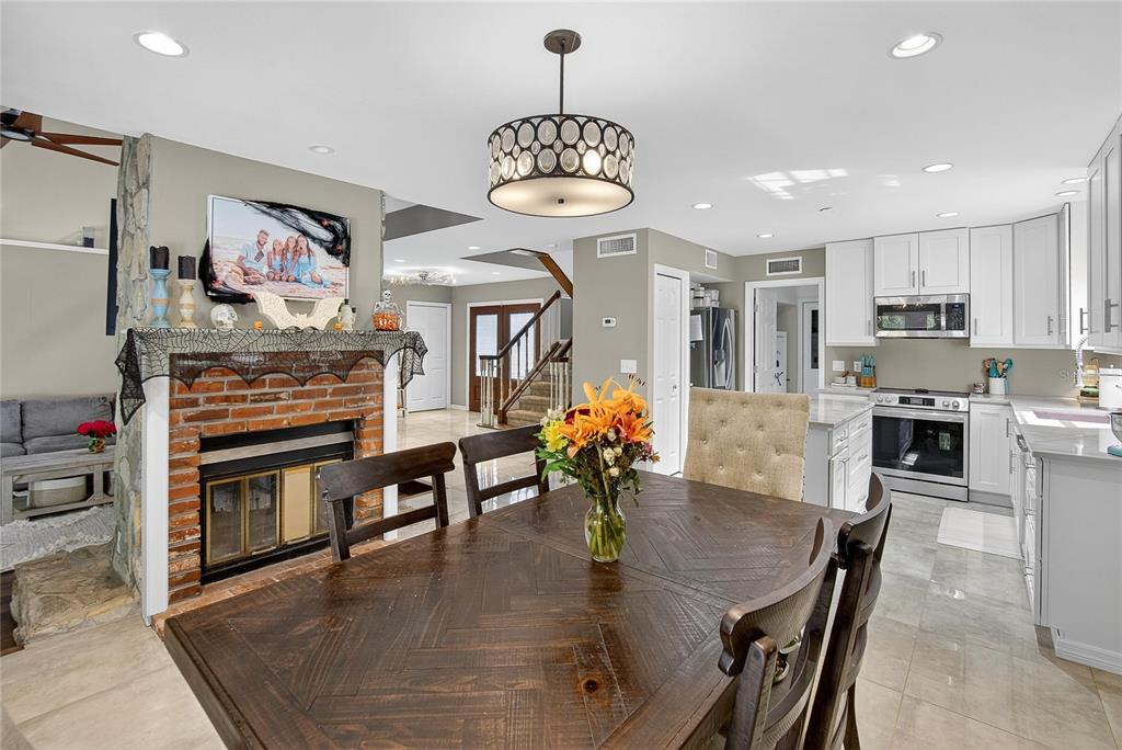 3309 Timberlee Road Wimauma, FL 33598 - Photo 11 of 55 a dining room with stainless steel appliances kitchen island granite countertop a table chairs and a refrigerator