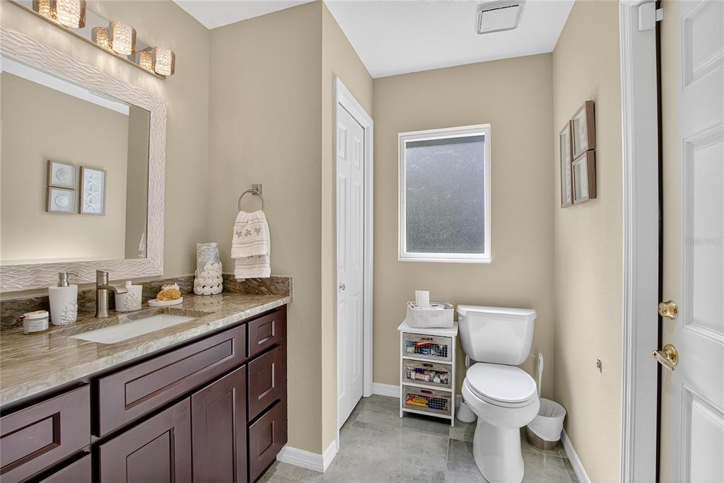 3309 Timberlee Road Wimauma, FL 33598 - Photo 26 of 55 a bathroom with a granite countertop toilet sink and mirror