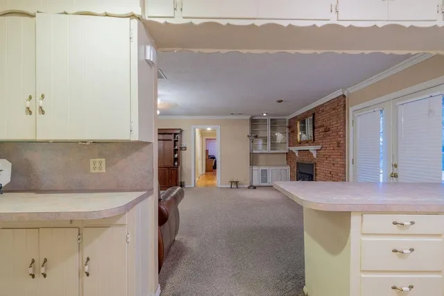 a view of kitchen with cabinets and window
