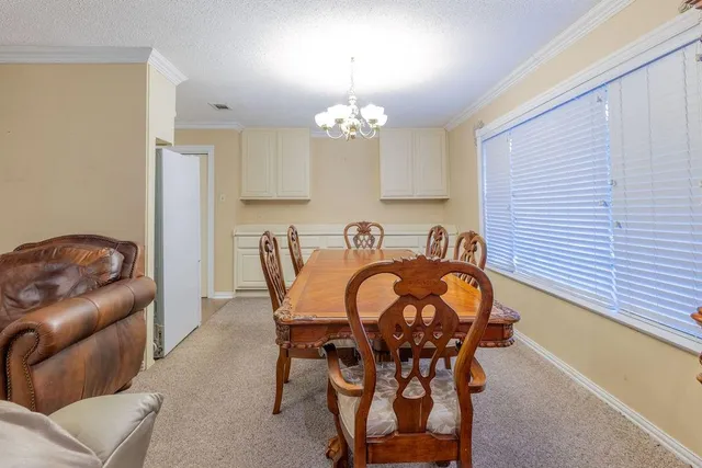 a view of a dining room with furniture and chandelier