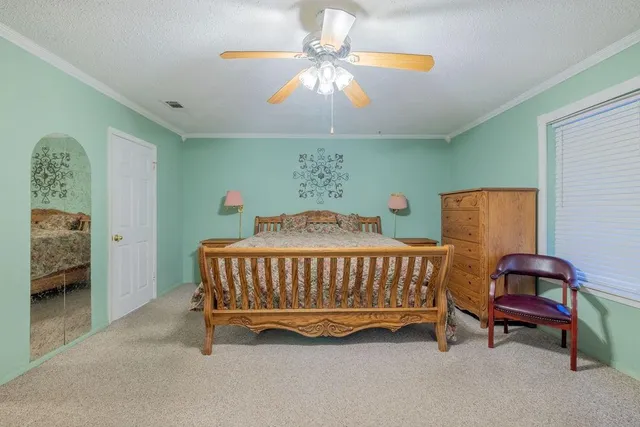 a spacious bedroom with a bed and a chandelier