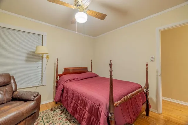 a bedroom with bed and wooden floor