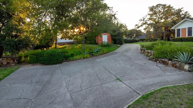 a front view of a house with garden and trees