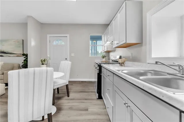 a kitchen with a sink cabinets and wooden floor