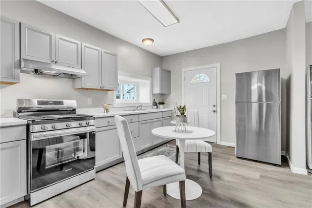 a kitchen with stainless steel appliances a stove a sink dishwasher and a refrigerator