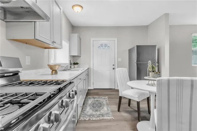 a kitchen with stainless steel appliances granite countertop a stove a sink and a refrigerator