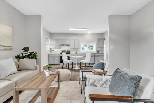 a living room with furniture and kitchen view