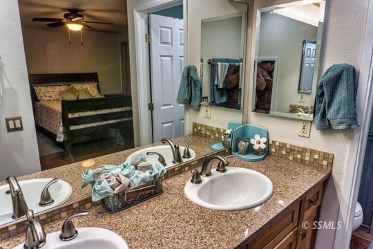 1236 Mountain View Drive Ridgecrest, CA 93555 - Photo 21 of 38 a bathroom with a granite countertop sink and a mirror