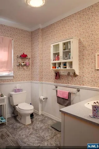 a bathroom with a granite countertop sink and a toilet