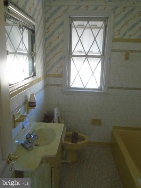 104 Wiltshire Road Baltimore, MD 21221 - Photo 2 of 13 a bathroom with a toilet sink and mirror