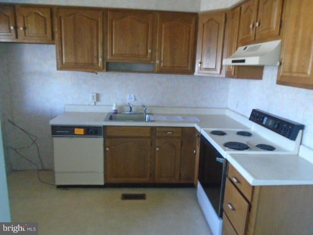 104 Wiltshire Road Baltimore, MD 21221 - Photo 11 of 13 a utility room with a sink a stove and cabinets
