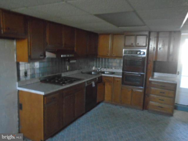 104 Wiltshire Road Baltimore, MD 21221 - Photo 4 of 13 a kitchen with a refrigerator stove and cabinets