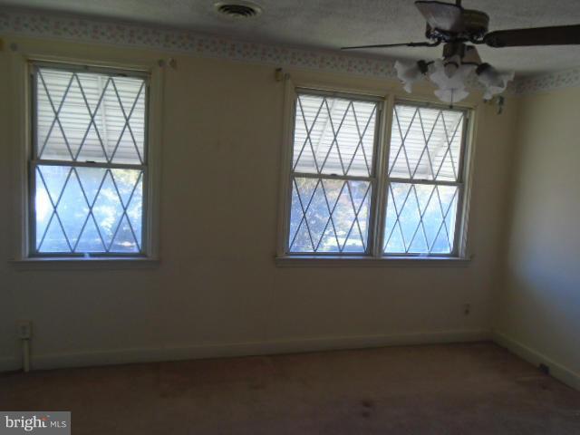 104 Wiltshire Road Baltimore, MD 21221 - Photo 7 of 13 an empty room with windows