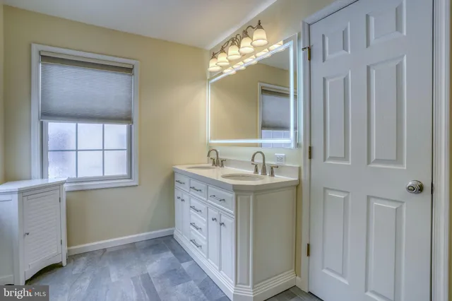 a bathroom with a granite countertop sink a light fixture and a mirror