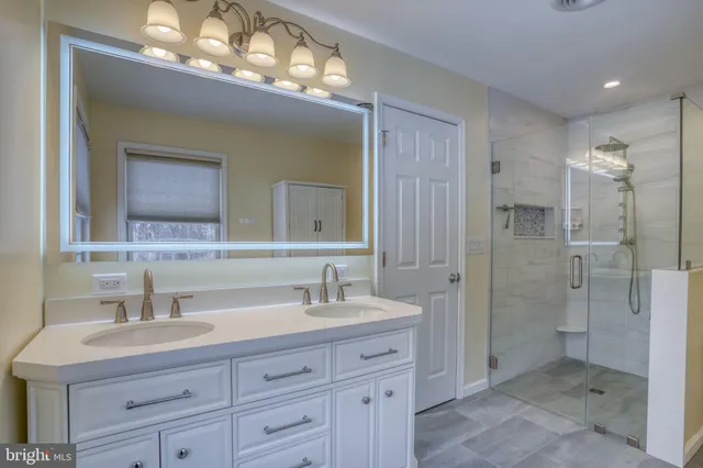 a bathroom with a double vanity sink mirror and shower
