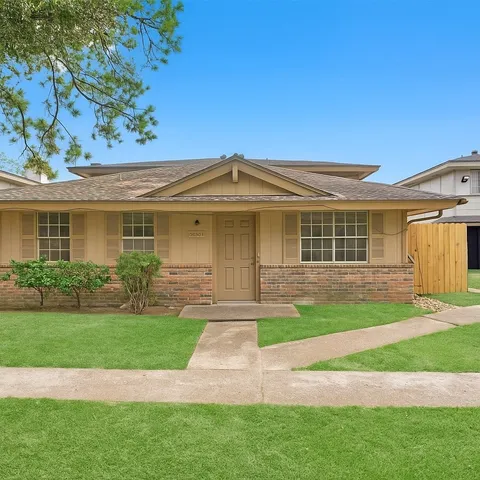 a front view of a house with a yard and potted plants
