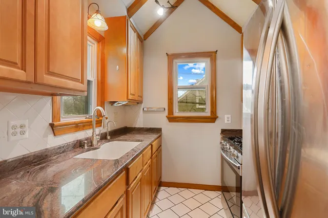 a kitchen with stainless steel appliances granite countertop a sink and a refrigerator