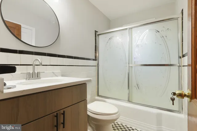 a bathroom with a sink a toilet and a mirror