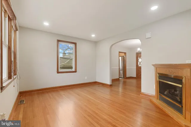 an empty room with wooden floor and fireplace